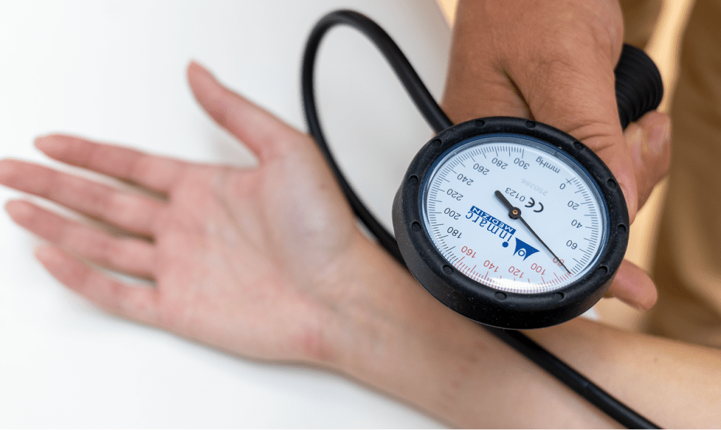 Lekar opšte prakse meri krvni pritisak pacijentkinji pomoću aparata za pritisak.